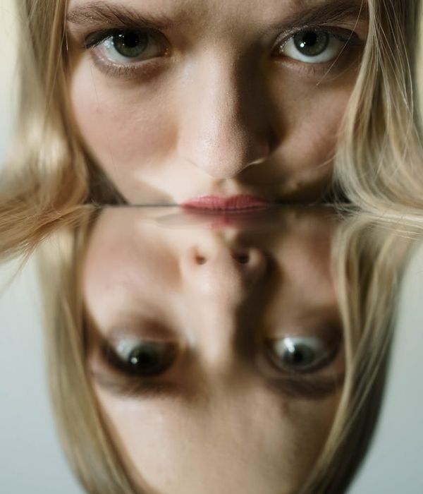 Woman with calm expression focusing, with violet light highlighting her eyes.